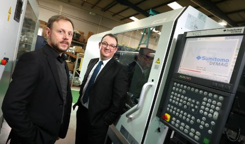 OPG colleagues standing next to a moulding machine