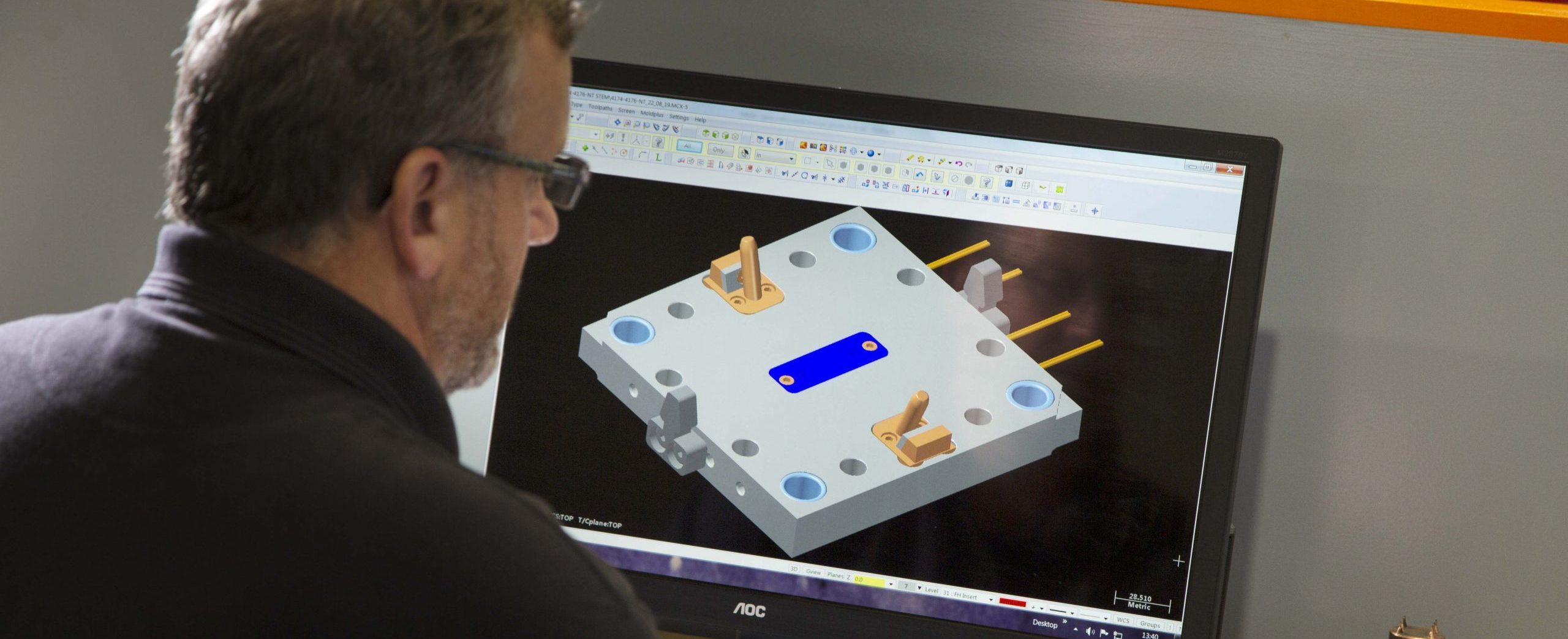 Colleague looking at tool design files on computer