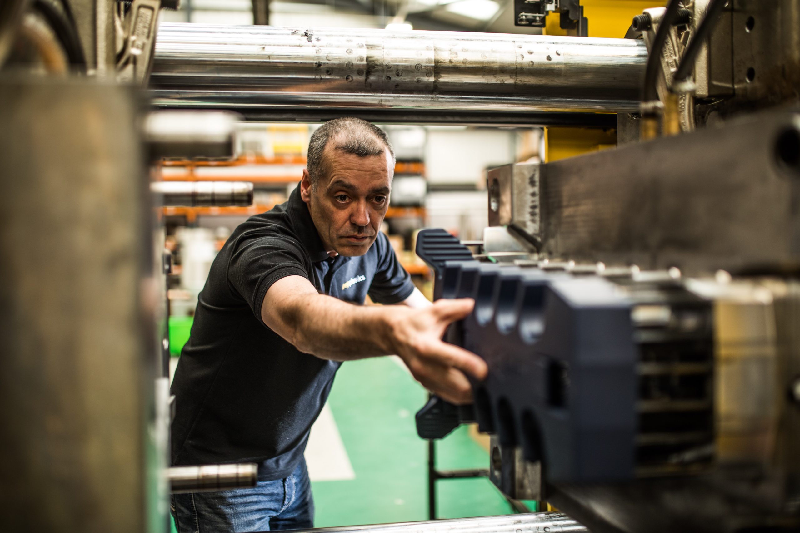 Colleague reaching into moulding machine